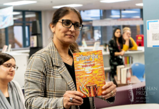 Gurpreet Bains, Languages Department Head at L.A. Matheson Secondary School, Surrey, British Columbia, Nov. 15, 2022 Gurpreet Bains holding book by award winning Punjabi author at presentation for Dhahan Youth Award activity