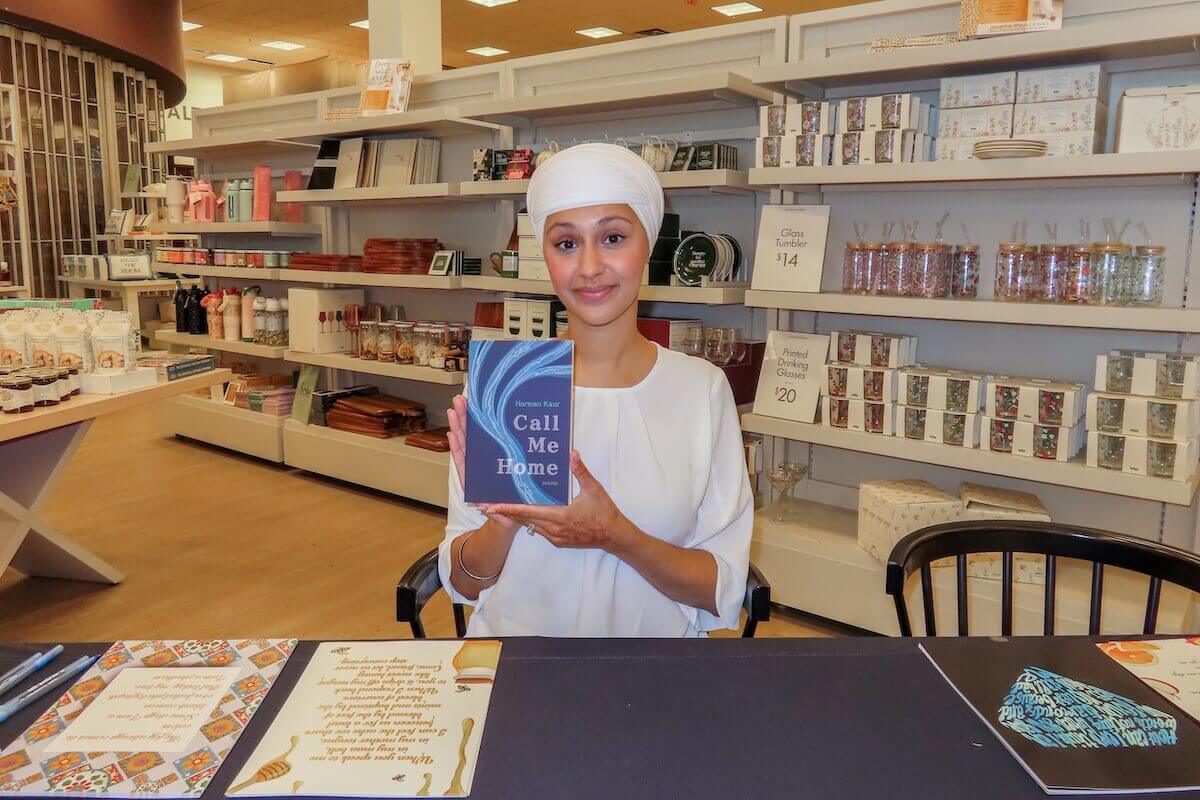 Harman Kaur in a bookshop with her book, Call Me Home
